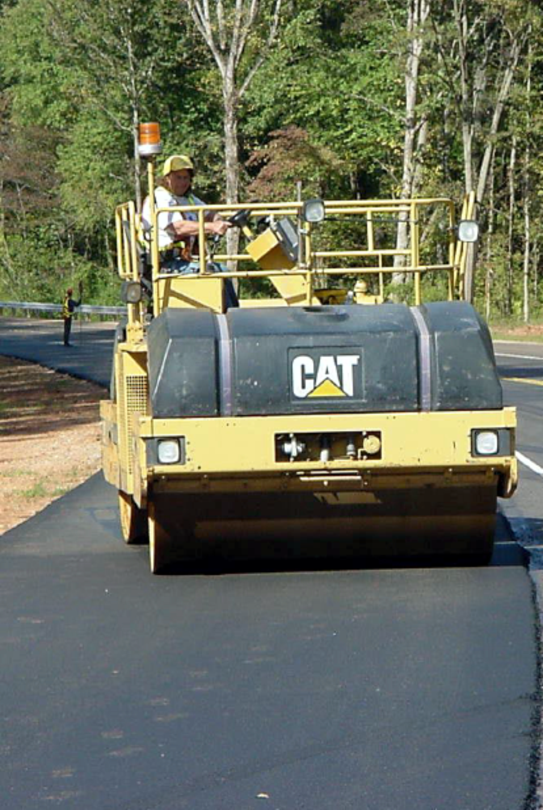 CAT compaction roller finishing a freshly paved asphalt highway
