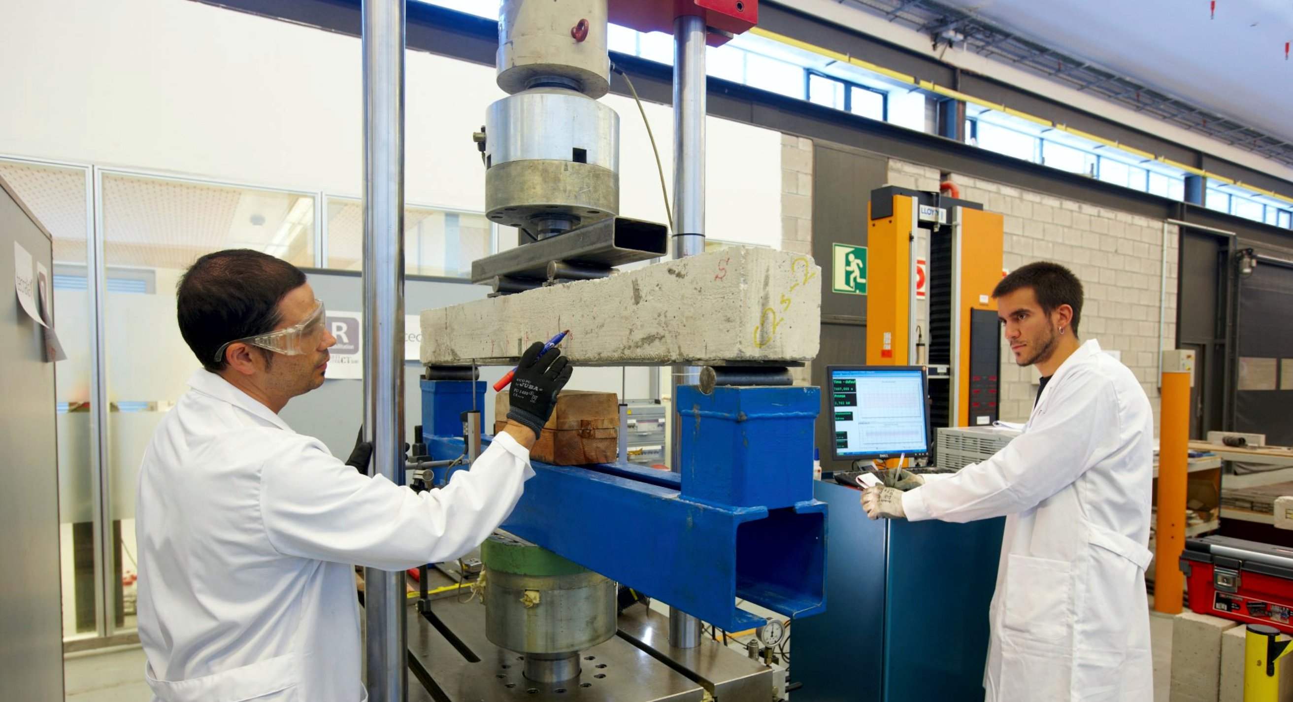 Materials scientists evaluating pavement specimens in the laboratory